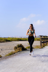 Happy sporty woman jogging outdoors
