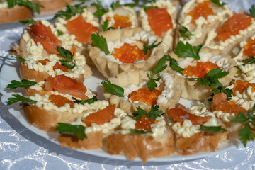 Set of delicious tartlets with red caviar, closeup. Many tartlets with butter and red caviar on a plate