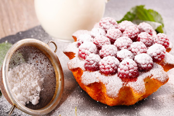 muffin decorated with raspberries and green leaves