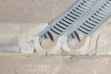 Fototapeta premium Drainage grating for drain of rain water. two gutters of the drainage system on the sidewalk