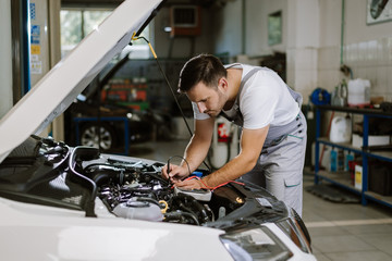 Fototapeta na wymiar Auto mechanic working on car diagnostic in a repair shop