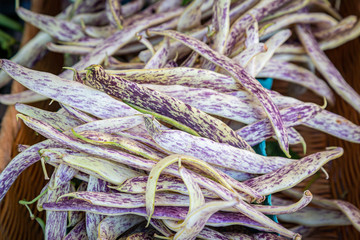 Dragon tongue beans for sale on a market stall, with a shallow depth of field