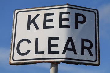 Keep clear road sign in blue sky background, horizontal