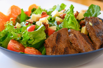 Delicious meat salad with roast beef, mushrooms and vegetables.Tasty meat salad. White background.