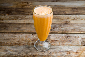 Fresh orange glass on wooden background