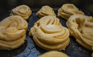 Raw yeast buns sprinkled with sugar before being sent to the oven