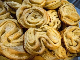 Fresh pastries - puff pastry rolls sprinkled with sugar, photographed in close-up