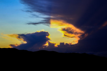 Mountains silhouette and sun rays through dark dramatic clouds. Part of set.