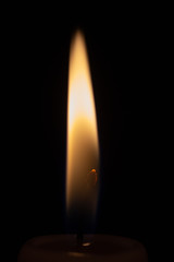 Single Burning Wax Candle on Black Background