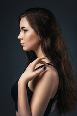 Portrait of a beautiful girl in profile on a homogeneous background. Beautiful smooth skin model