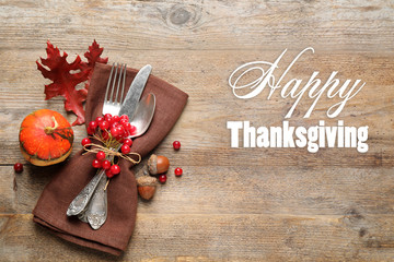 Cutlery and autumn decorations on wooden table, flat lay. Happy Thanksgiving day