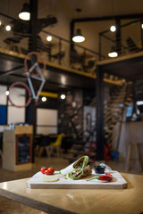 Appetizing fast food on a wooden board with fresh vegetables.