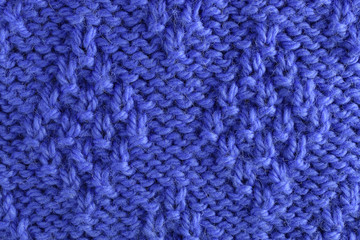 Blue wool yarn knitted texture with large stitches. Hand knitted rhombus pattern. Closeup