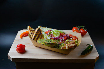 An appetizing meal on a wooden board with fresh vegetables.