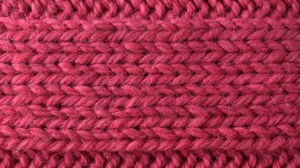 Naklejka na ściany i meble Pink bulky wool yarn. Handmade knitted texture. Stockinette stitch pattern. Horizontal orientation. Closeup. Copy space