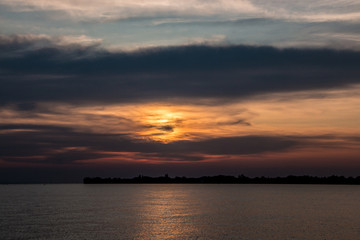 Little black spit of land into the water and a golden sunset