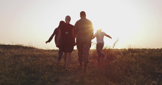 Soldier and his family walking on a meadow