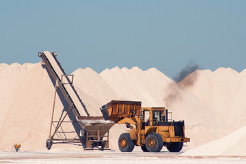 Salt factory in the open air, the excavator collects salt.