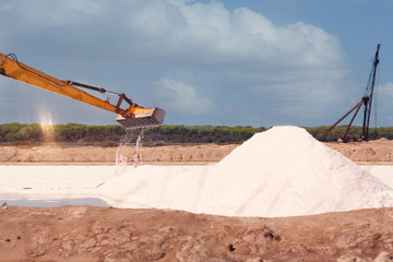 Salt factory in the open air, the excavator collects salt.