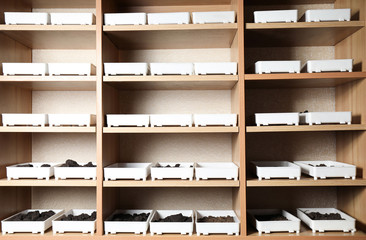 Containers with soil samples on shelves indoors. Laboratory research