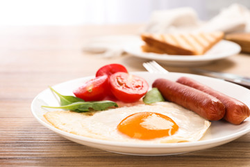 Tasty breakfast with fried egg on wooden table, closeup