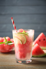 Glass of refreshing watermelon drink on wooden table