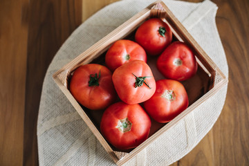 Fresh ripe tomatoes in wooden crate.