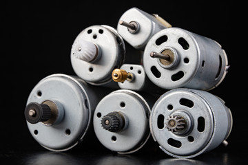Small electric motors on a dark countertop. Electrical accessories on a workshop table.