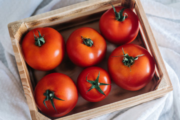 Fresh ripe tomatoes in wooden crate.