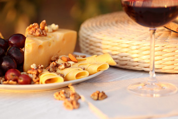 Composition with wine and snacks on white wooden table outdoors, closeup