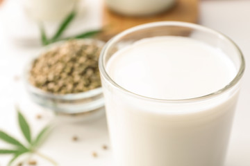 Composition with glass of hemp milk on white table, closeup. Space for text