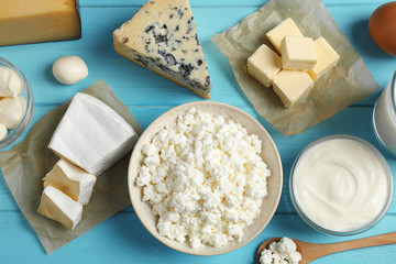 Different dairy products on blue wooden table, flat lay