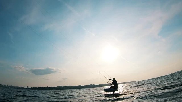 A man is professionally riding a kiteboard