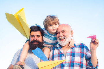 Multi generation. Portrait of happy father giving son piggyback ride on his shoulders and looking...