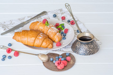  croissants on a white plate with berries breakfast in Paris for a beloved food on a date