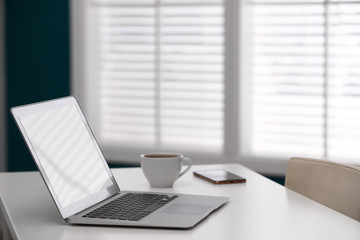 Comfortable workplace with modern laptop on desk in home office, space for text