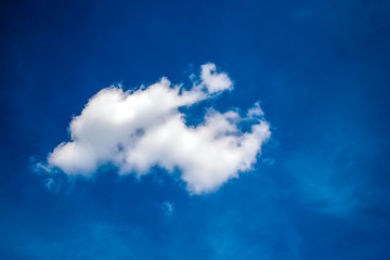 Fototapeta na wymiar white lonely cloud in blue sky background