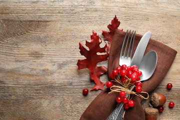 Cutlery and autumn decorations on wooden background, flat lay with space for text. Happy...