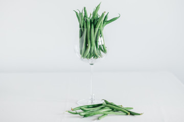 fresh green beans in glass. green beans isolated on a white backgroundbackground hand holding green kidney bean in glass. carrot with a crat