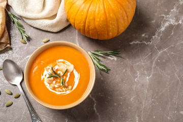 Delicious pumpkin soup in bowl on marble table, flat lay. Space for text