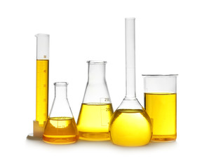 Laboratory glassware with yellow liquid on white background