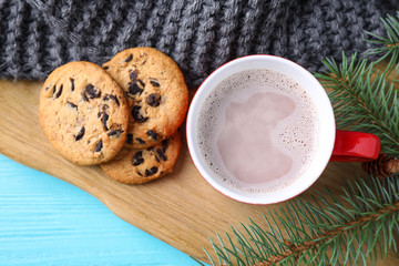 Flat lay composition with cup of tasty cocoa on blue wooden table