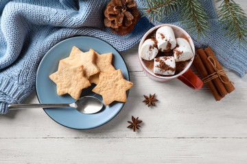 Flat lay composition of tasty cocoa with marshmallows on white wooden table
