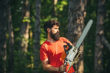 Woodcutter with chainsaw on sawmill. Woodworkers lumberjack. Man doing mans job. Woodcutter with...