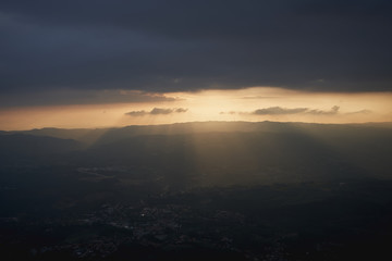 Beautiful sunset in the mountains. Storm clouds and sun rays through clouds      