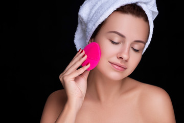 Beautiful brunette woman massage her face with a beauty massager. Her skin fresh, clean and flawless. Spa procedure concept