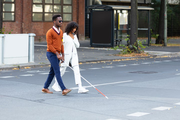 Woman Assisting Blind Man On Street