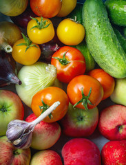 Delicious fresh tomatoes, green cucumbers and spicy garlic..Harvest vegetables and fruits..Photo in warm colors..