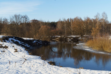 landscape of a winter river with open water and snowy shores