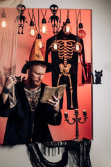 Halloween man with smile on dark background. Magic, enchantment, witchcraft. Halloween man with...